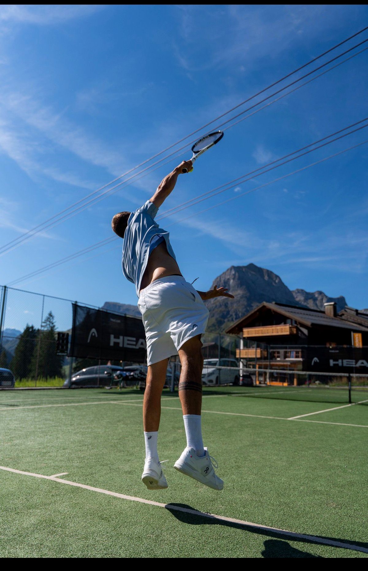 Julian Erhart beim Aufschlag auf dem Tennisplatz in Oberlech am Arlberg