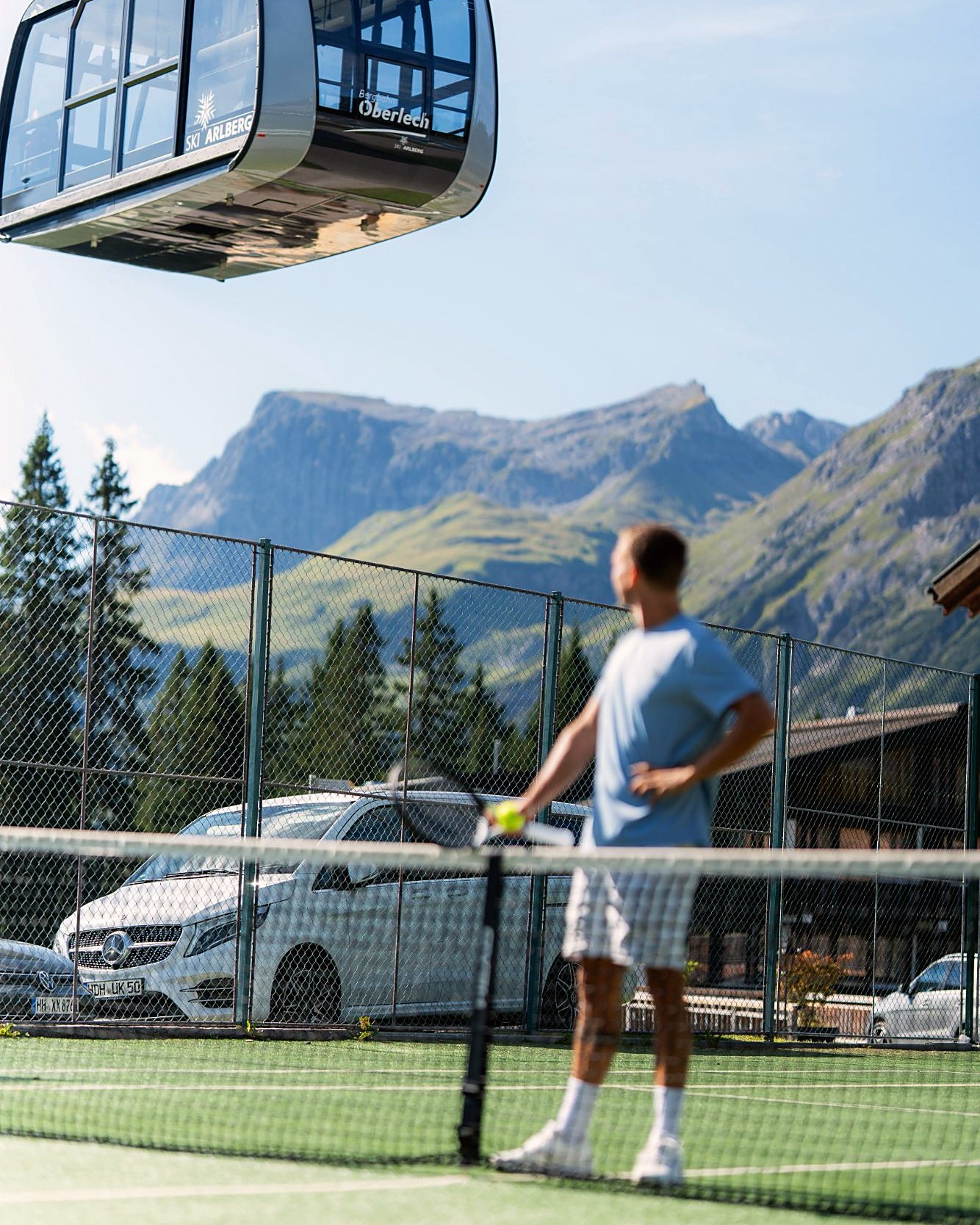 Tennisplatz in Oberlech am Arlberg, darüber die Bergbahn